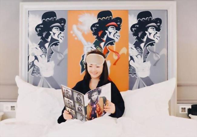 Woman reading in Bed at the Aria Hotel Budapest