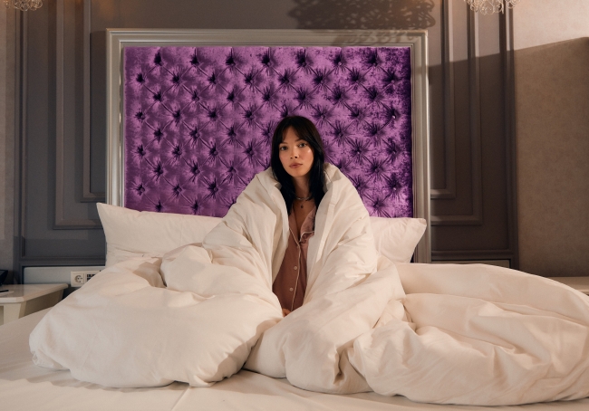 Woman reading in Bed at the Aria Hotel Budapest